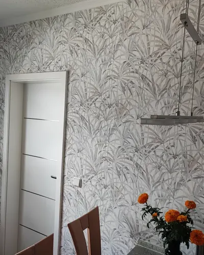 Esszimmer mit großflächigem Palmenblatt-Motiv über die komplette Wand