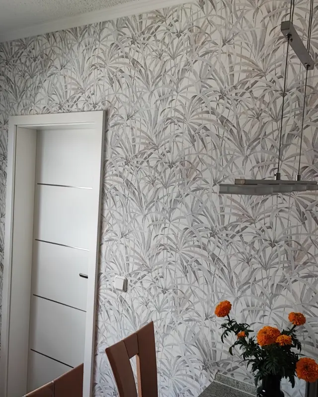 Esszimmer mit großflächigem Palmenblatt-Motiv über die komplette Wand