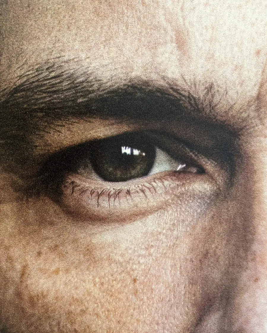 Extreme Nahaufnahme eines gedruckten Auges. Wimpern, Augenbraue und Hautstruktur sind einzeln aufgelöst, die Druckkörnung ist sichtbar.