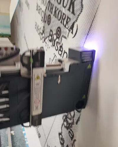 Der Druckkopf steht dicht vor einer Wand, auf der eine Weltkarte mit Ortsnamen entsteht.